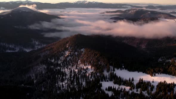 Aerial Revealing Shot of Mountain Valley with Sea of Clouds at Sunrise.