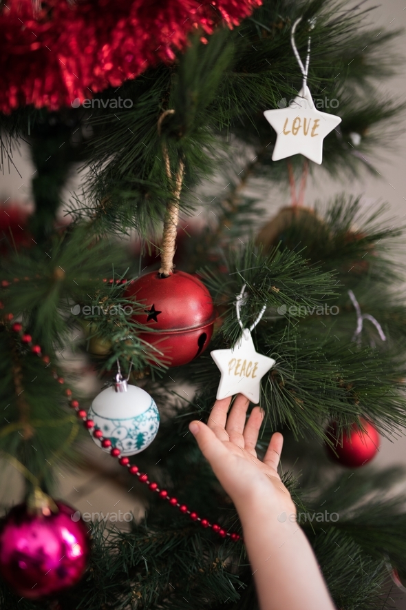 Decorating a christmas tree with baubles, decorations, beads, love