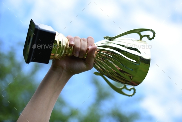 Cup in the hand of a teenager against the blue sky - Stock Photo - Images