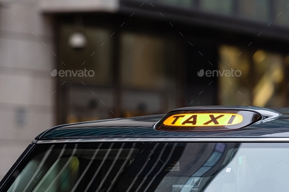 A british london black taxi cab sign with defocused background