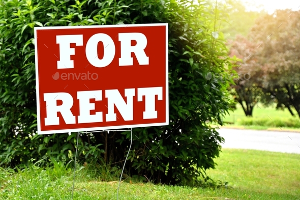 FOR RENT sign in a yard with grass and bushes. House home office space for rent. - Stock Photo - Images