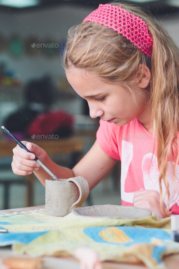 Girl making her first pottery in ceramic Stock Photo by przemekklos