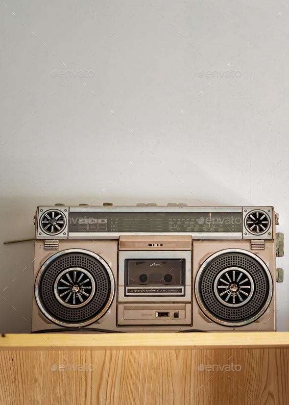 Retro outdated portable stereo boombox radio cassette recorder from 80s on the shelf.