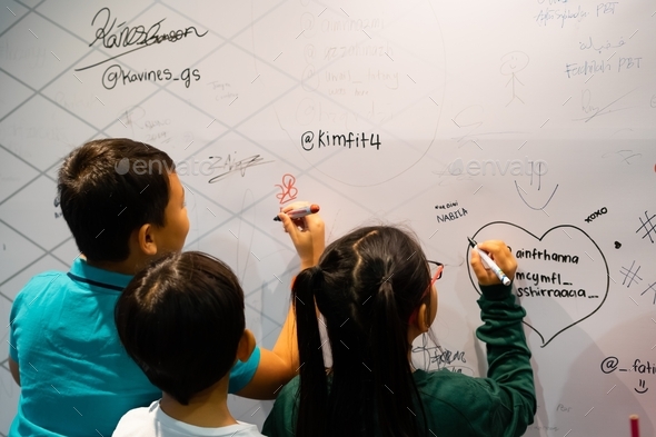 children placing signatures to the wall