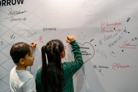 children placing their signatures to the walls