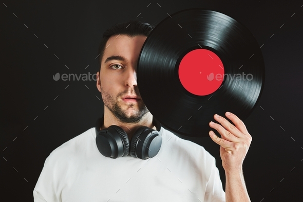 Man holding vinyl record covering face. Vintage music style. Turntable disk. Classic audio. Old disc