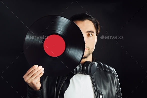 Man holding retro vinyl record covering face. Rock style. Vintage music style. Music passion. Mockup