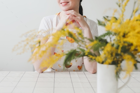 Beautiful young smiling woman with mimosa flowers on white background