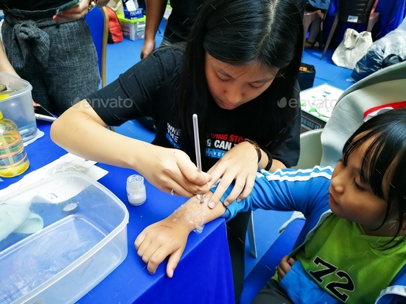 making a temporary tattoo on the child\'s hand