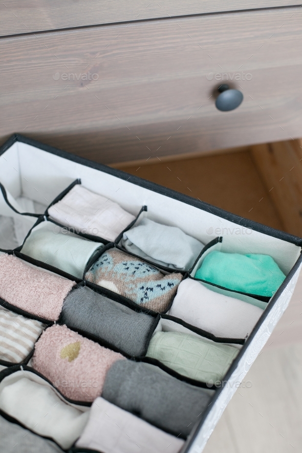 Folded socks. Decluttering and vertical organazing of socks in the drawer in chest of drawers.