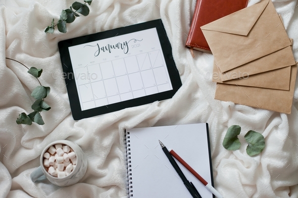 Calendar flat lay, month january, woman writing to-do list for a new month, planning, planner