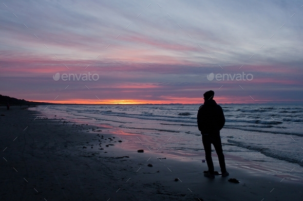 A guy watching the sunset by the sea, alone, loneliness, reflecting, thoughts, silhouette, man alone