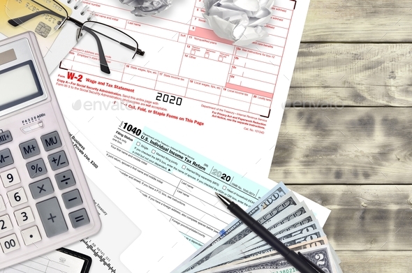 IRS form 1040 Individual income tax return and W-2 wage and tax statement lies on office table and