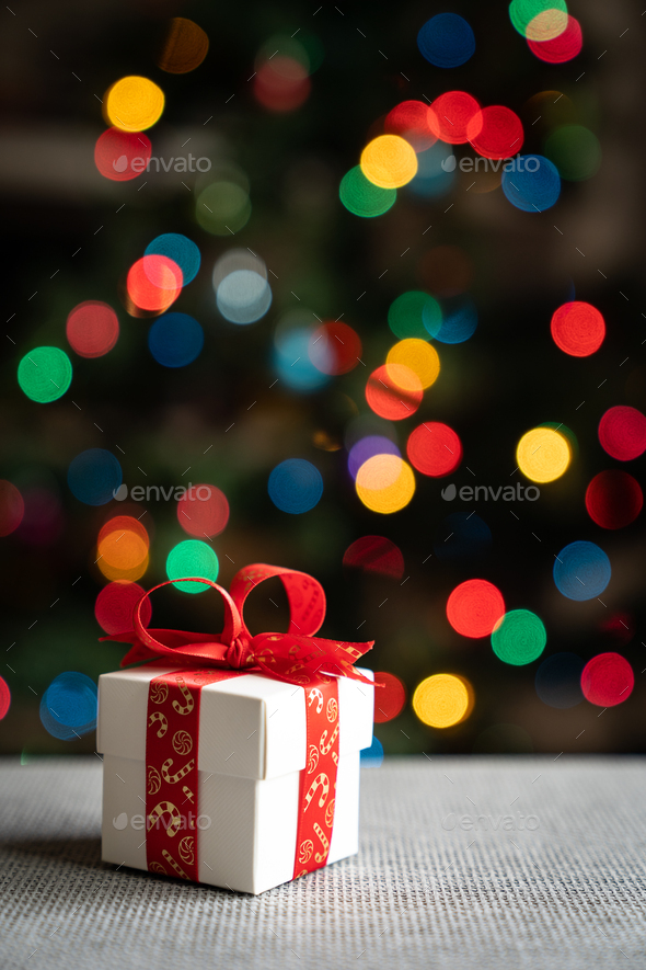 Gift in front of christmas tree - Stock Photo - Images