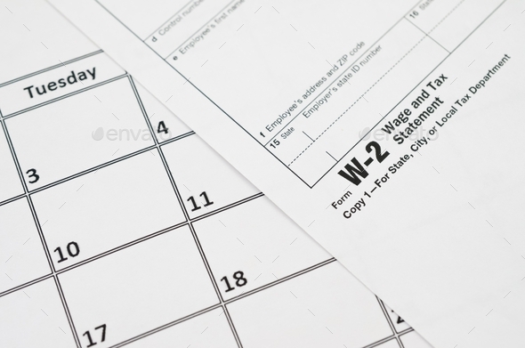 W-2 Wage and Tax statement blank lies on empty calendar page - Stock Photo - Images