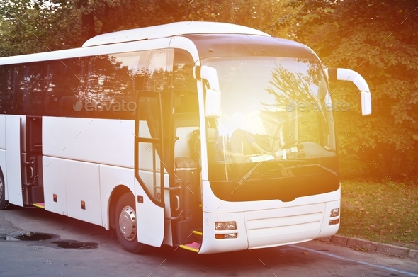 White tourist bus for excursions. The bus is parked in a parking lot near the park