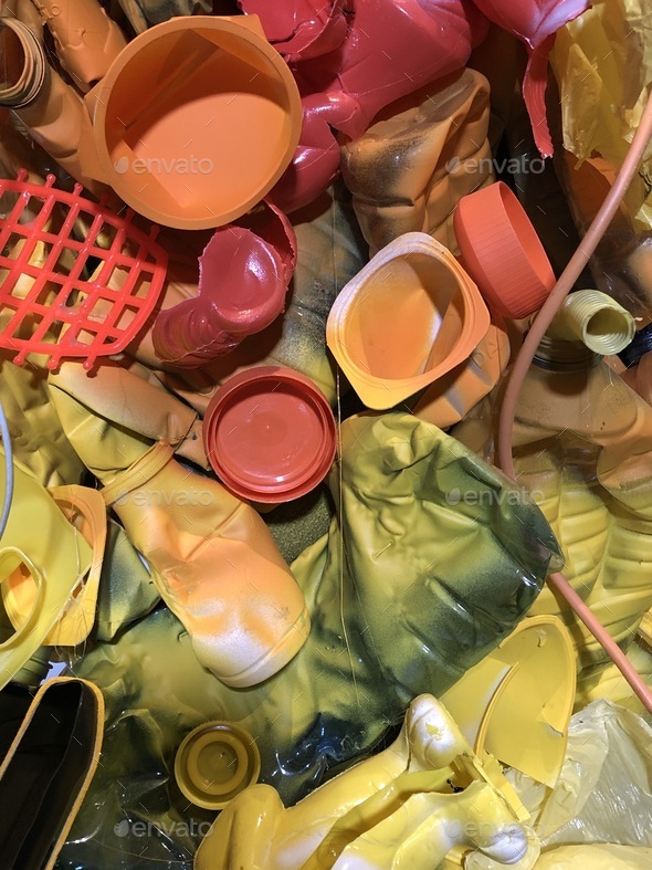 Colorful plastic trash of yellow and orange color, waste garbage throw away, reduce plastic trash