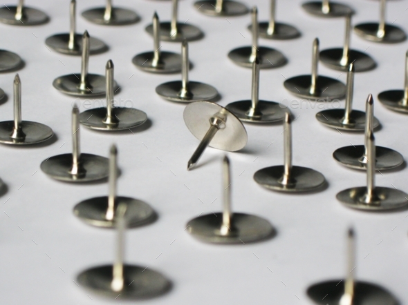 Metal stationery thumbtacks lie on a white background - Stock Photo - Images