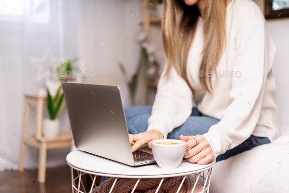 Distance learning online education and work. Business woman with coffee cup typing at laptop, sittin