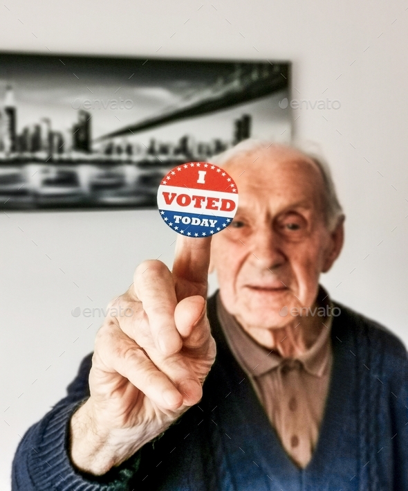 Selective focus image of senior man holding voting sticker with i voted today text.