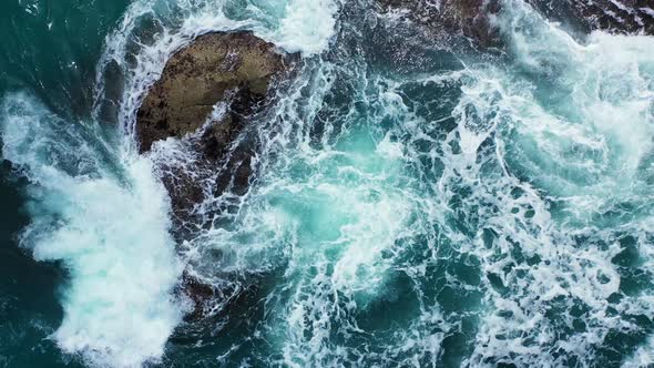 rough sea waves crashing on the rock in the emerald sea.Aerial vertical background alt