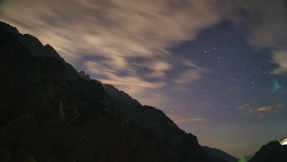Steep mountain range There are stars and the Milky Way. moving clouds at night.