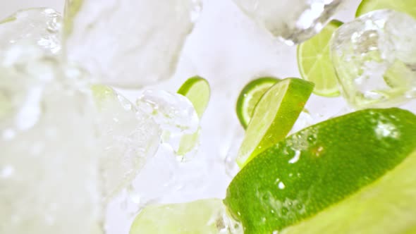 Super Slow Motion Shot of Lime Slices and Ice Cubes Falling on Black Background at 1000 Fps alt
