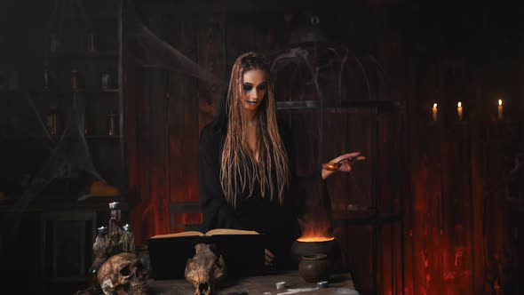 Halloween Witch Use Magic Book and Cauldron Prepare Poison or Love Potion alt
