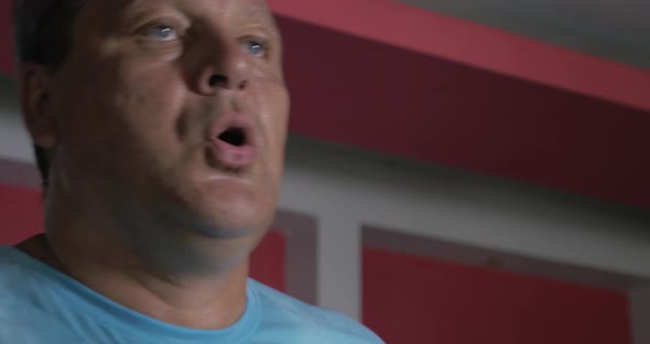 Sweat face of strong senior man running on treadmill alt