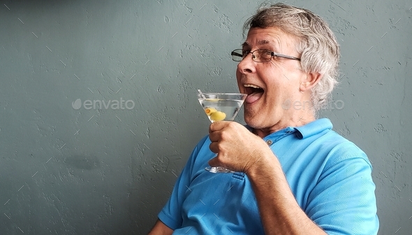 Active senior drinks vodka martini in candid portraits with face and emotions of happiness and joy.