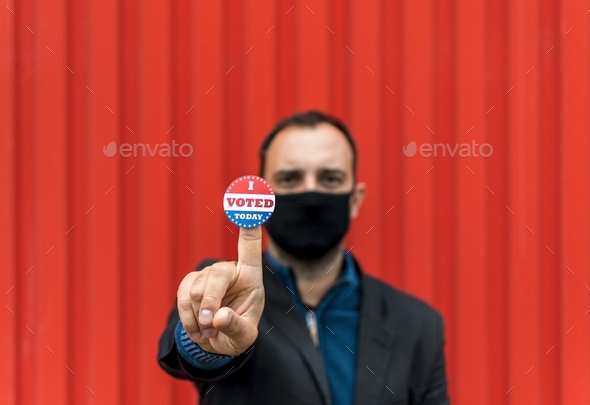 Selective focus image of man holding voting sticker with i voted today text.