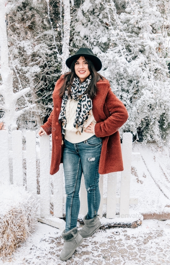 Full length portrait of woman wearing stylish winter clothes, standing in  front of snowy tree Stock Photo by anelehbakota