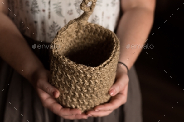 hanging knitted jute basket in hands of craftswoman