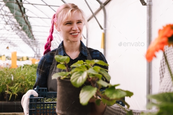 Young woman with pink hair working in garden mall