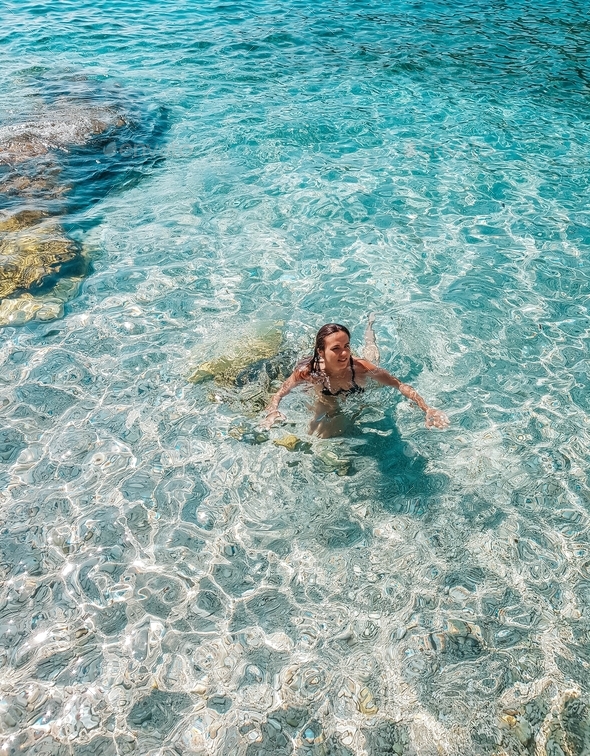 Young female swimming in crystal clear transparent sea. Water, summer ...