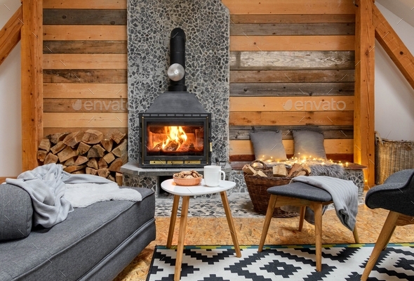 Cozy cabin interior with fireplace and beautiful furniture. Cookies and cup on coffee table.