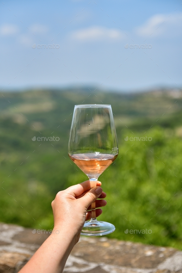 Selective focus personal perspective photo of woman holding glass of rose wine