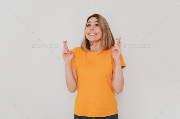 young European woman in casual clothes crossing fingers making wish come true gesture
