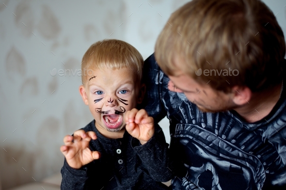 FAther and son play at home, painted faces