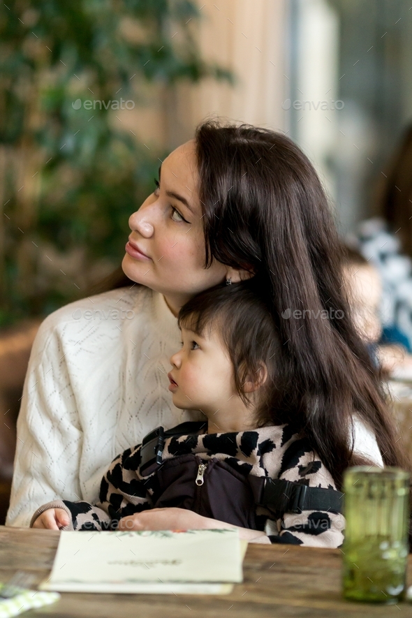 mom and daughter are sitting in a cafe, restaurant, bar