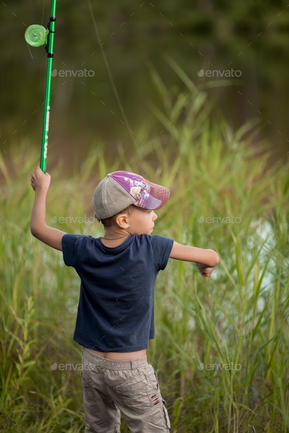 boy 6-7 years old fishing in the summer Stock Photo by aliliya