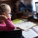 Little girl in eyelgasses studying online and using her laptop at home - PhotoDune Item for Sale
