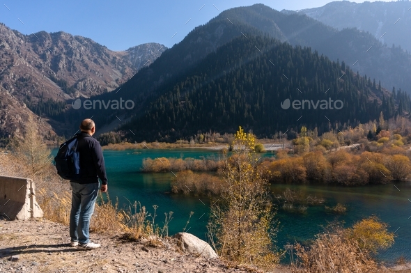 Man is standing before the beautiful lake - Stock Photo - Images