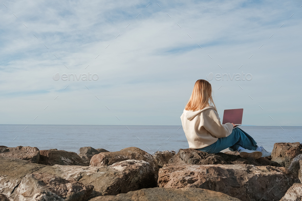 Remote work.Girl freelancer works remotely on the sea shore. workation, remote work,WFVH,Van Life vi
