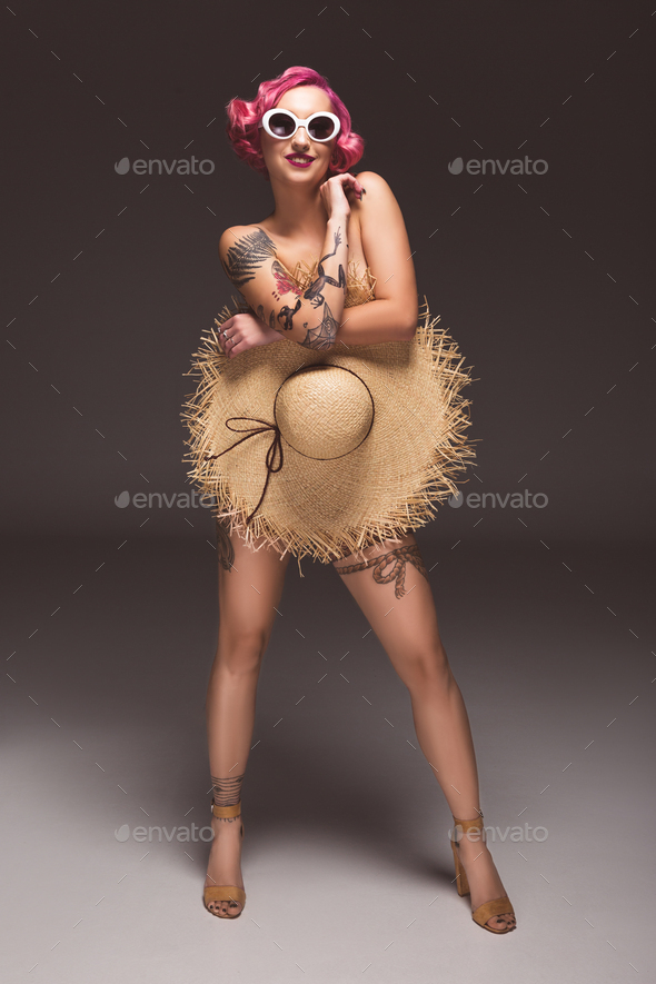 Pretty Naked Pin Up Girl In Sunglasses Covering By Straw Hat Infront Of Grey Background Stock