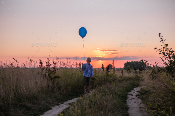 Happy Boy lets go Balloons to the sky. Run along the yellow field. - Stock Photo - Images