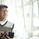 Senior citizen playing smartphone look out the window - PhotoDune Item for Sale