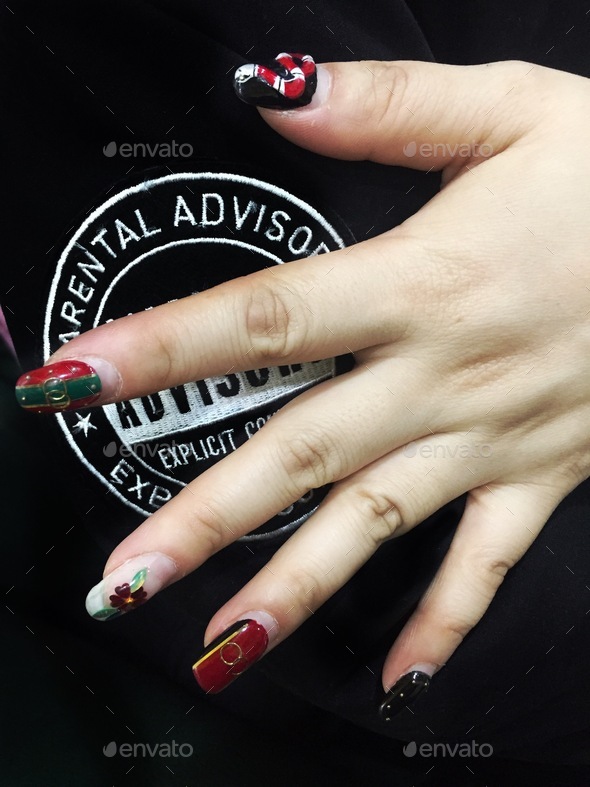 Close up of the hand with a nail art over a parental advisory T-shirt sign