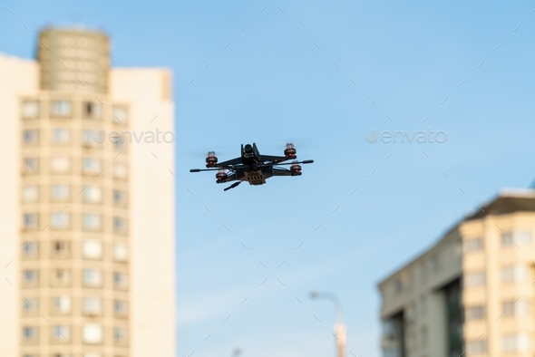 A small sports drone reconnaissance flies in the air among the buildings in the city