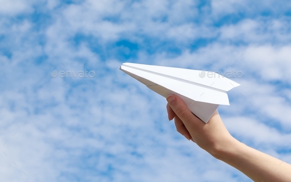 Woman's hand launches paper airplane into the sky Stock Photo by ...